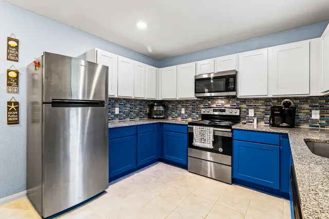 a kitchen with stainless steel appliances granite countertop a refrigerator stove a sink dishwasher and microwave