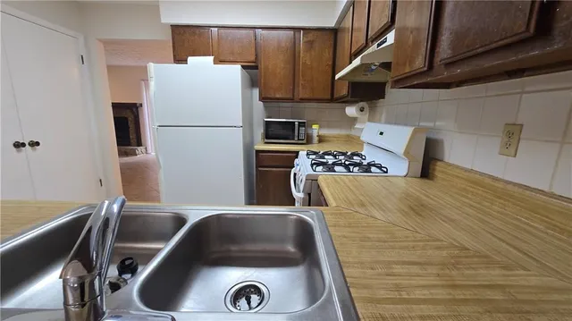 a kitchen with a refrigerator and a stove top oven