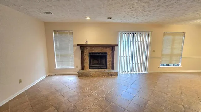 a view of an empty room with a fireplace and a window