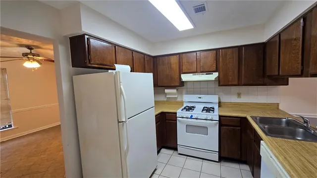 a kitchen with a refrigerator sink and cabinets