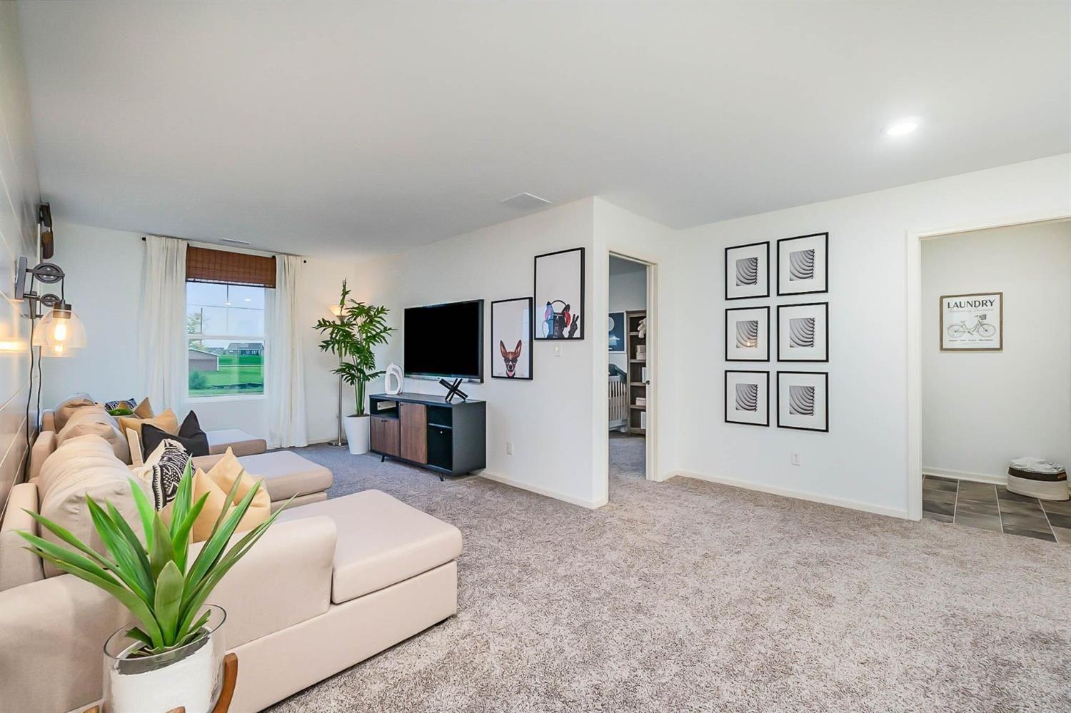 7718 West 103rd Street Crown Point, IN 46307 - Photo 16 of 47 a living room with furniture a flat screen tv and a chandelier