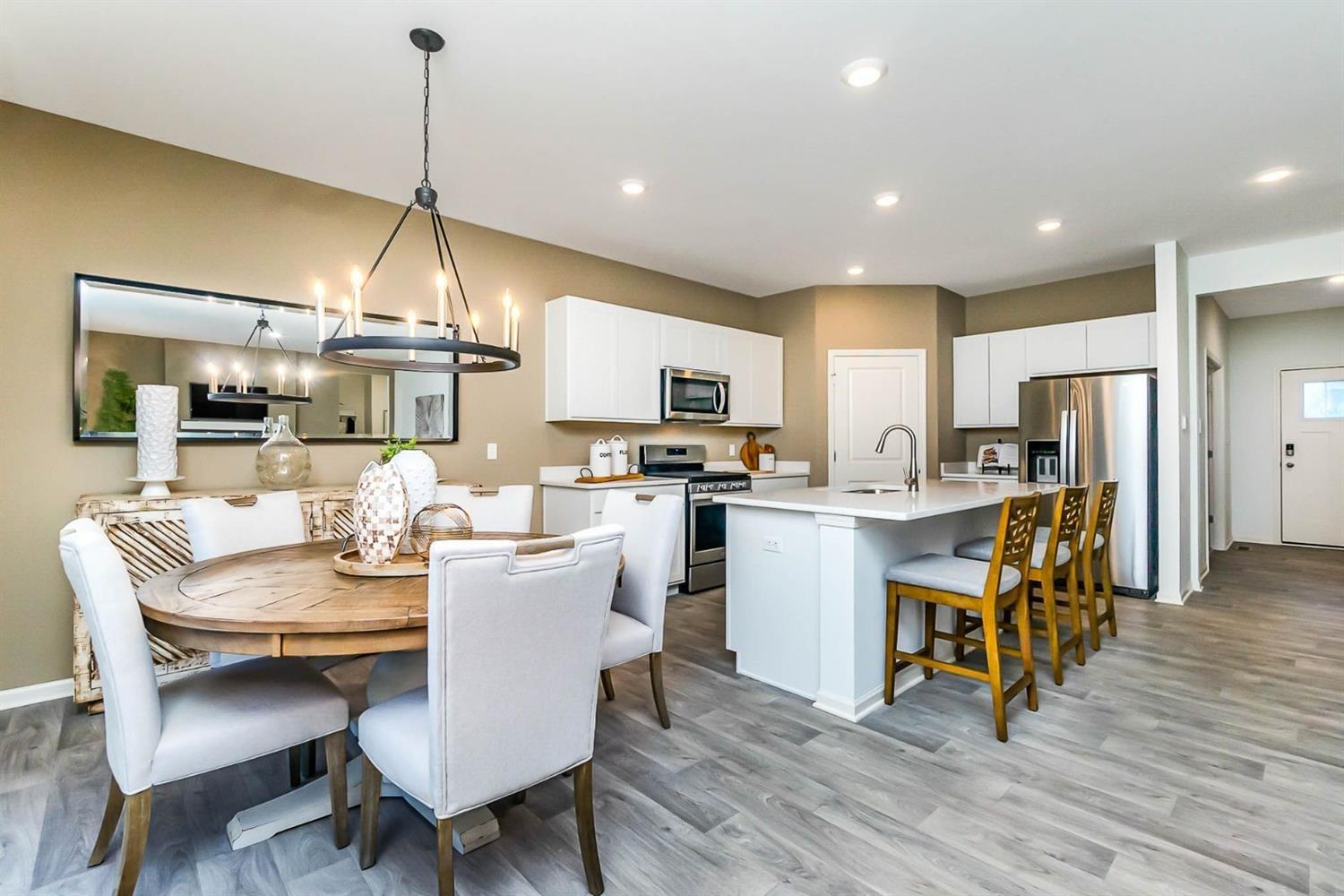 7718 West 103rd Street Crown Point, IN 46307 - Photo 6 of 47 a kitchen with a table chairs refrigerator and microwave