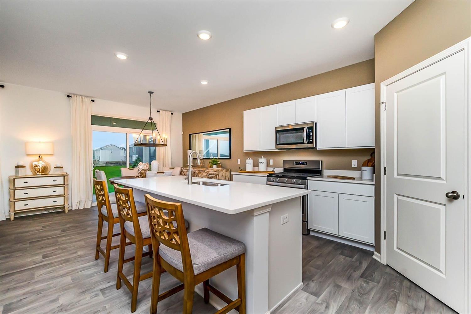 7718 West 103rd Street Crown Point, IN 46307 - Photo 7 of 47 a kitchen with a table chairs refrigerator and cabinets