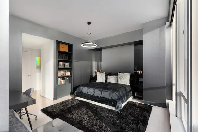 a bedroom with a large bed and a chandelier