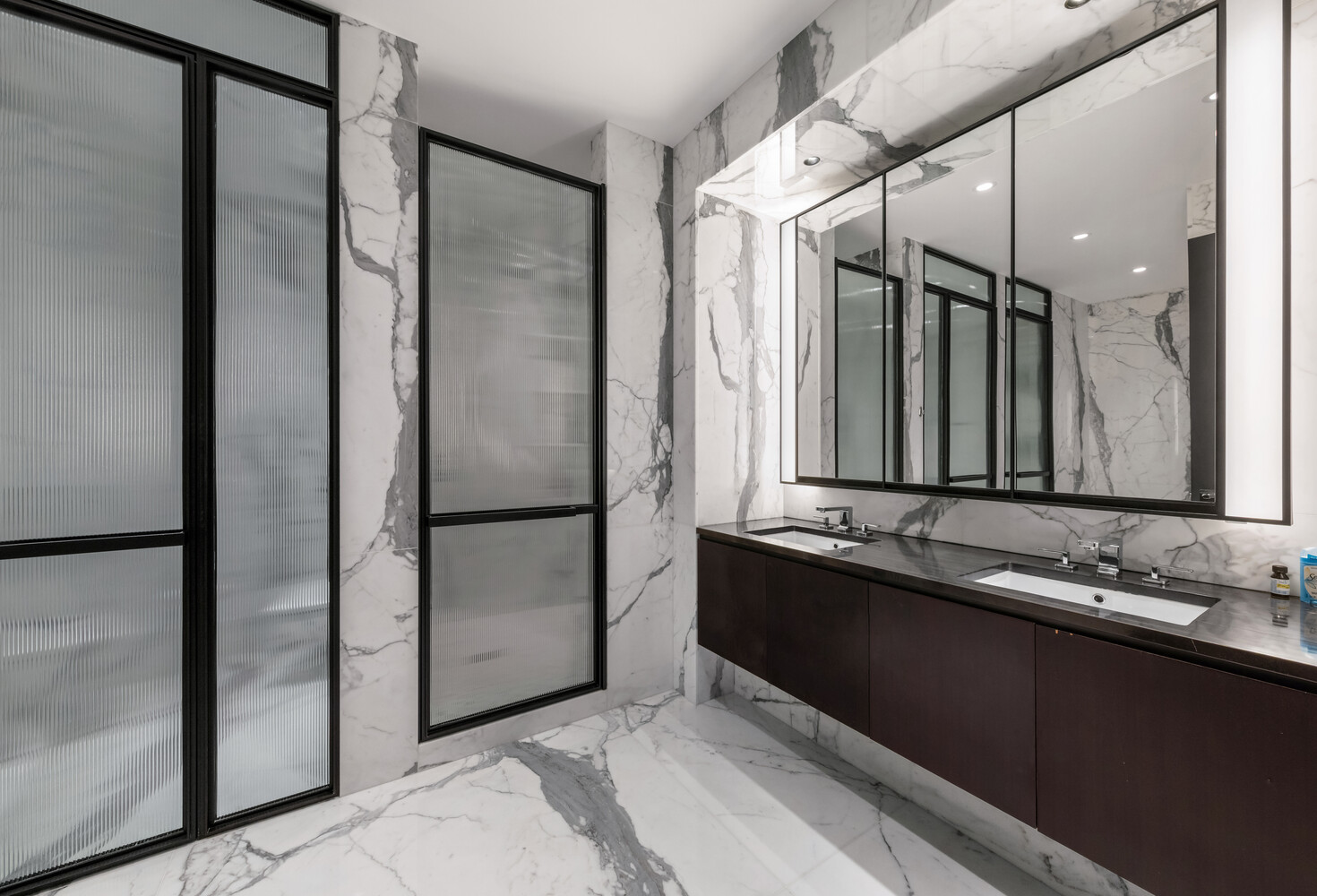 157 West 57th Street, Unit 52/53B Manhattan, NY 10019 - Photo 18 of 20 a bathroom with a double vanity sink and mirror