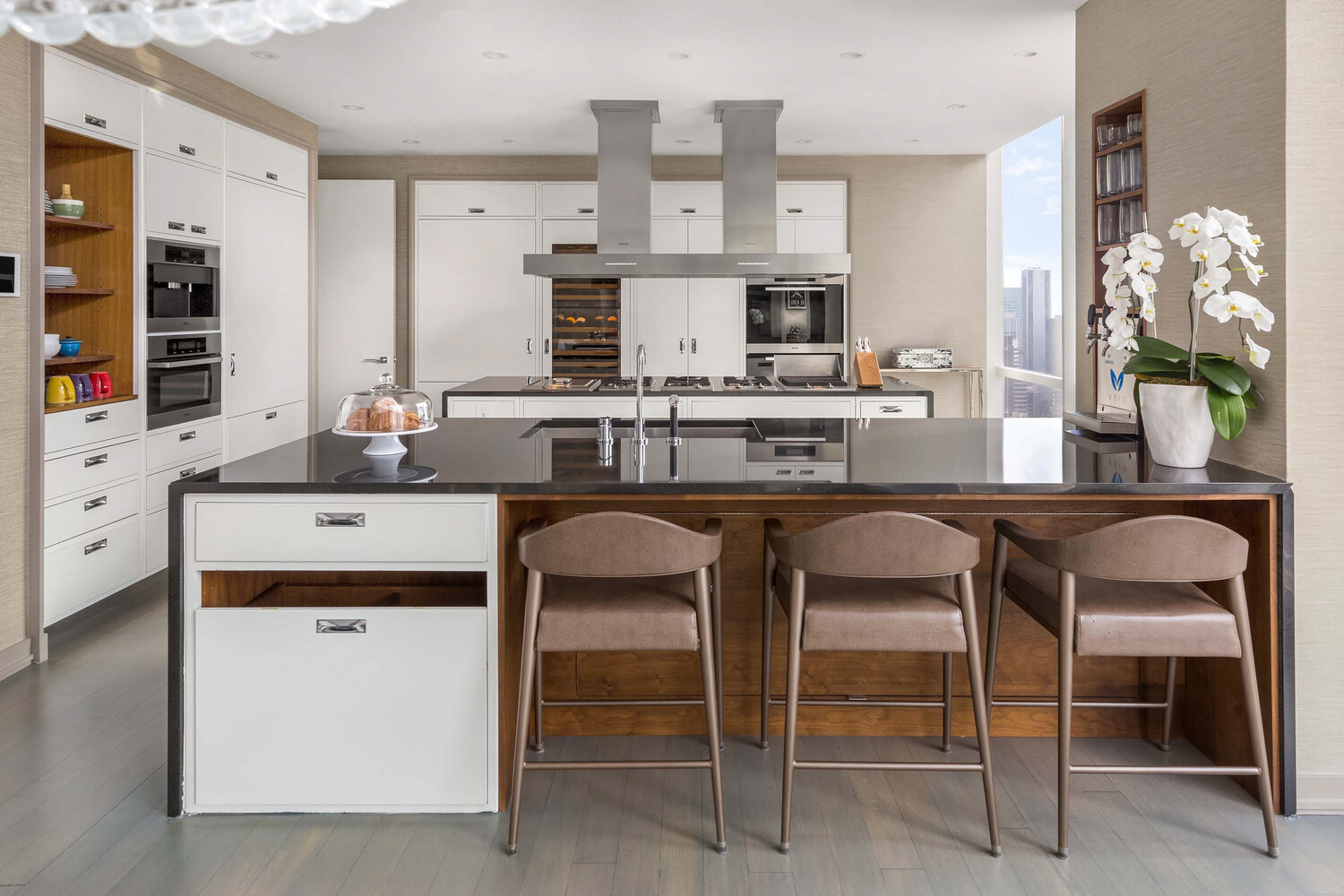 157 West 57th Street, Unit 52/53B Manhattan, NY 10019 - Photo 8 of 20 a kitchen with a stove a sink and white cabinets
