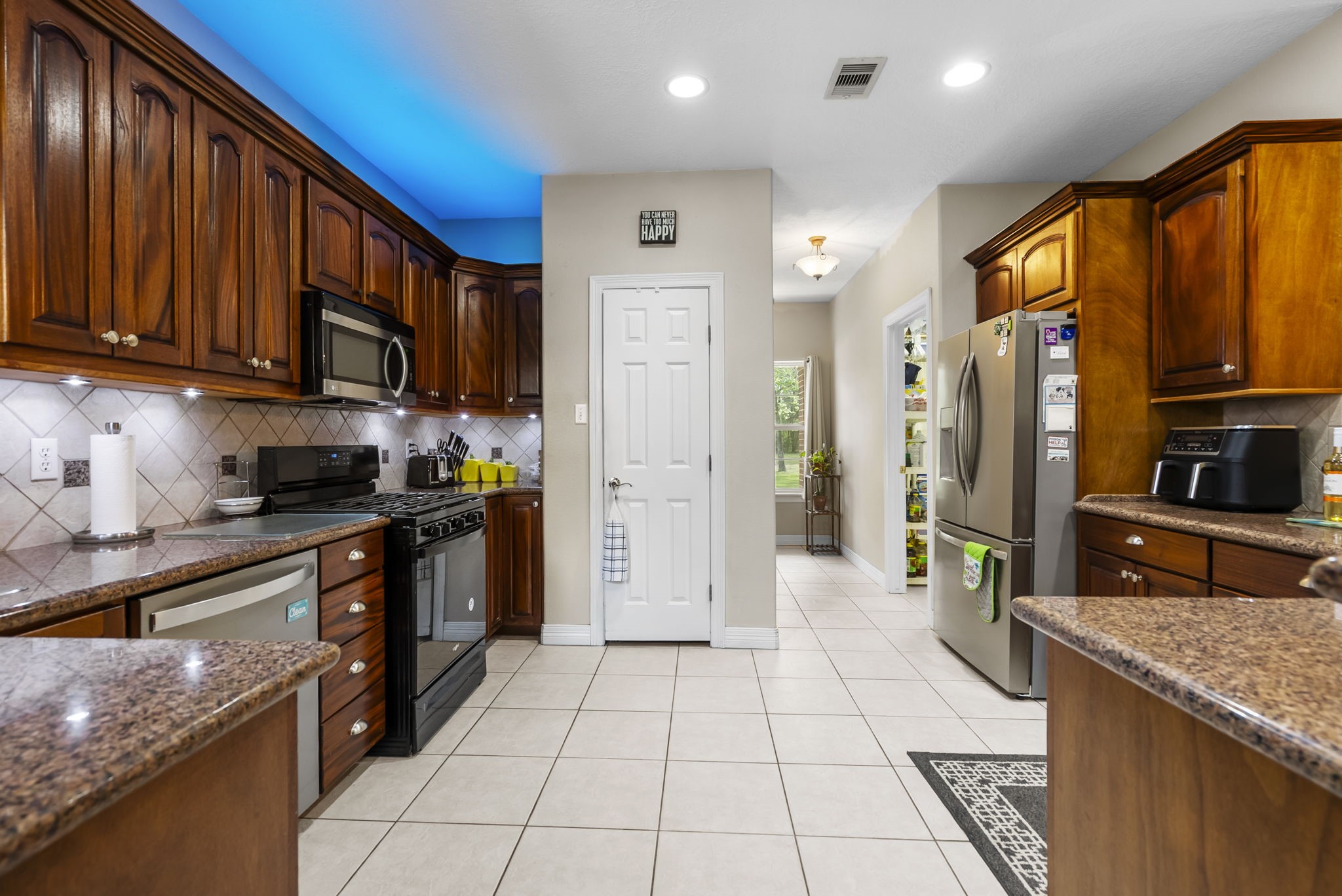 15524 Jim Branch Road Dayton, TX 77535 - Photo 20 of 40 a kitchen with stainless steel appliances granite countertop a refrigerator a stove top oven and a sink with wooden floor