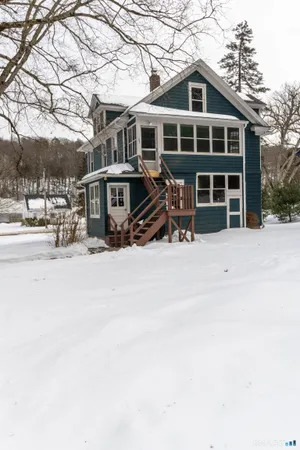 a front view of a house with a yard covered in snow