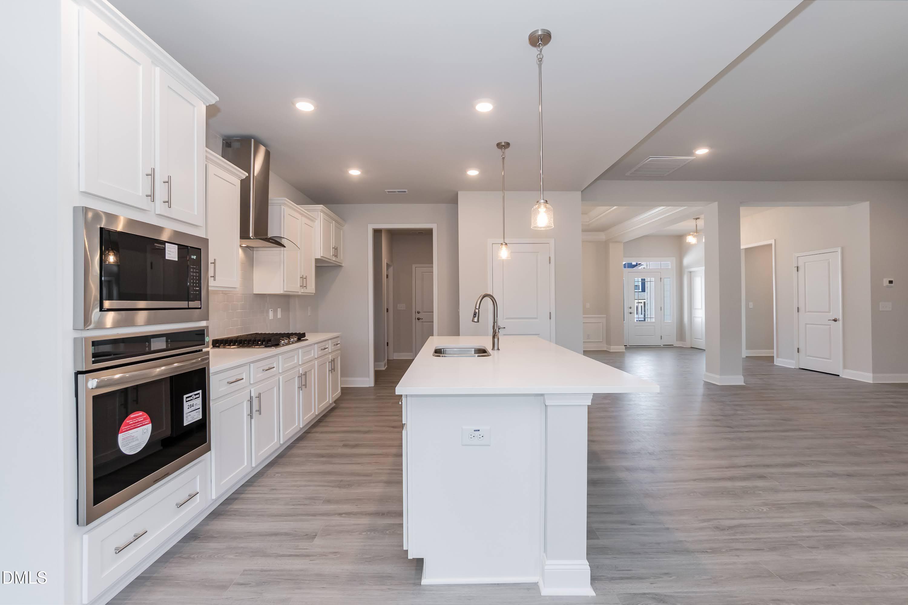 49 Galway Road Lillington, NC 27546 - Photo 10 of 39 a kitchen with stainless steel appliances kitchen island granite countertop a stove top oven a sink dishwasher and a refrigerator with wooden floor
