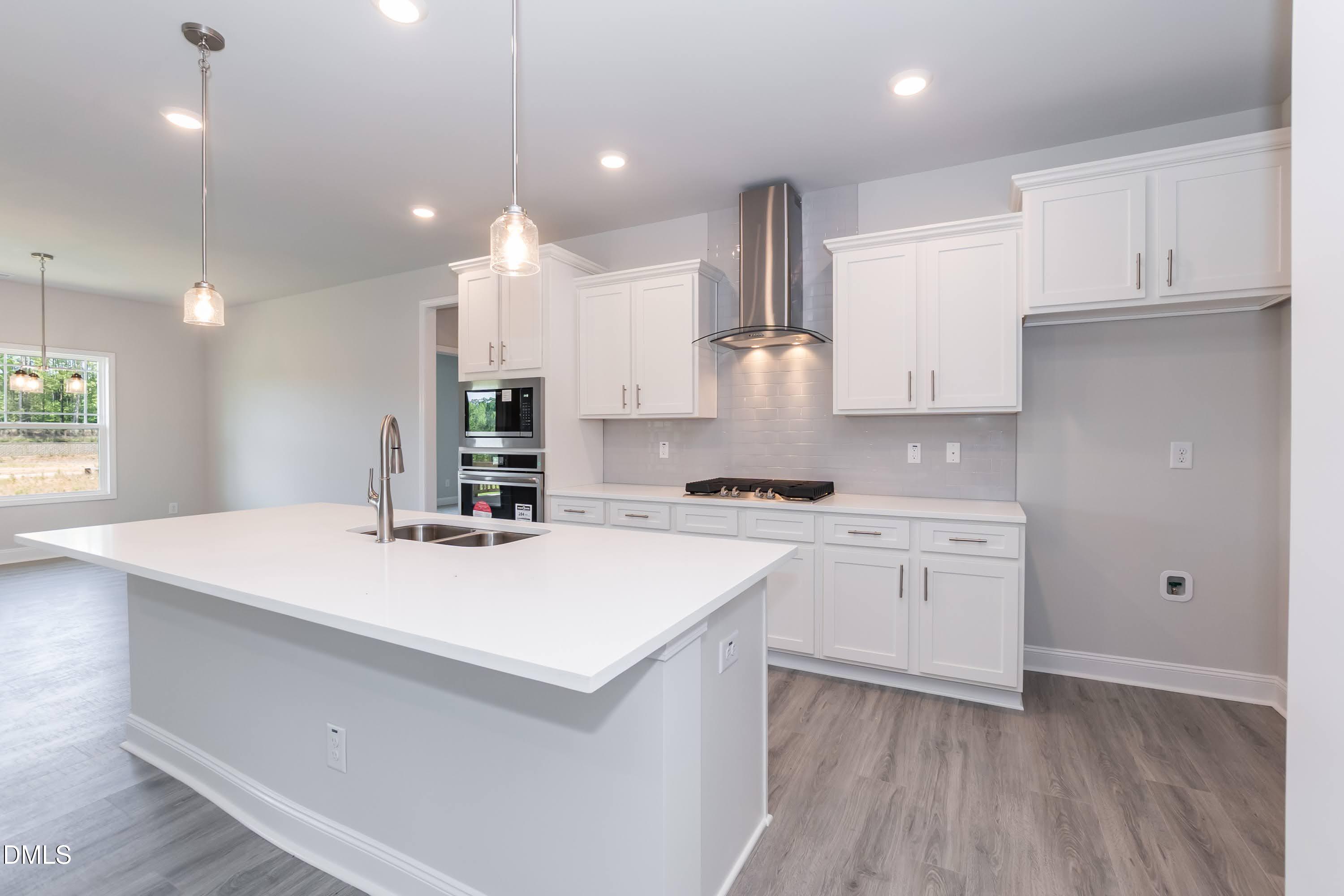 49 Galway Road Lillington, NC 27546 - Photo 14 of 39 a kitchen with a sink a stove a refrigerator and white cabinets