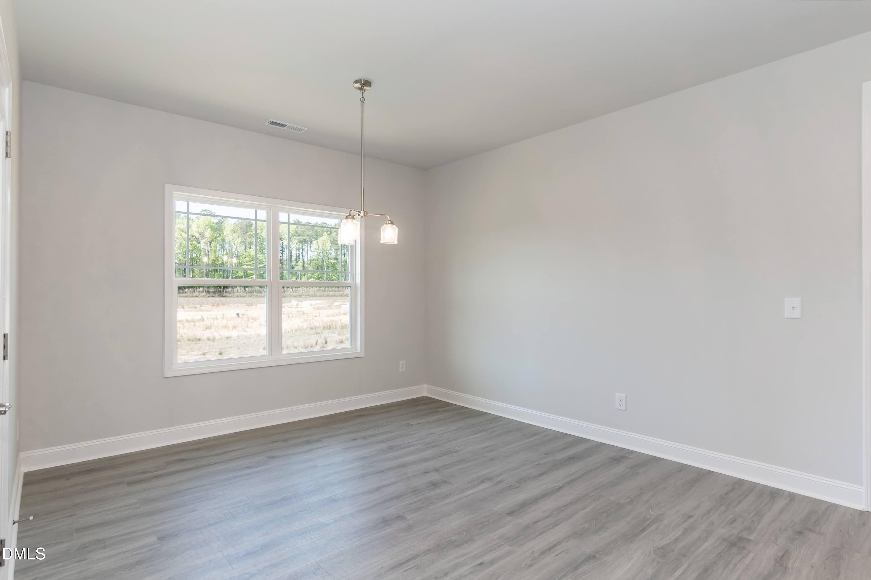 49 Galway Road Lillington, NC 27546 - Photo 16 of 39 an empty room with wooden floor and windows
