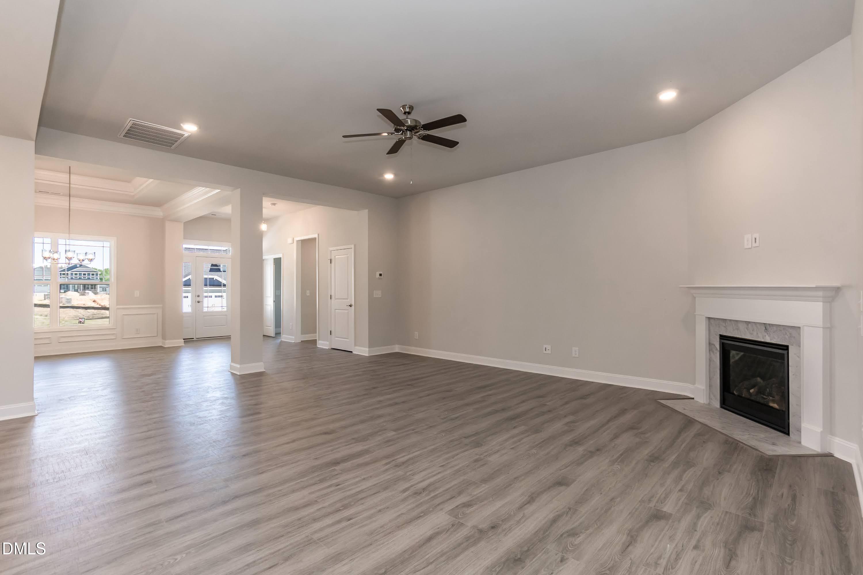 49 Galway Road Lillington, NC 27546 - Photo 7 of 39 an empty room with wooden floor fireplace and windows
