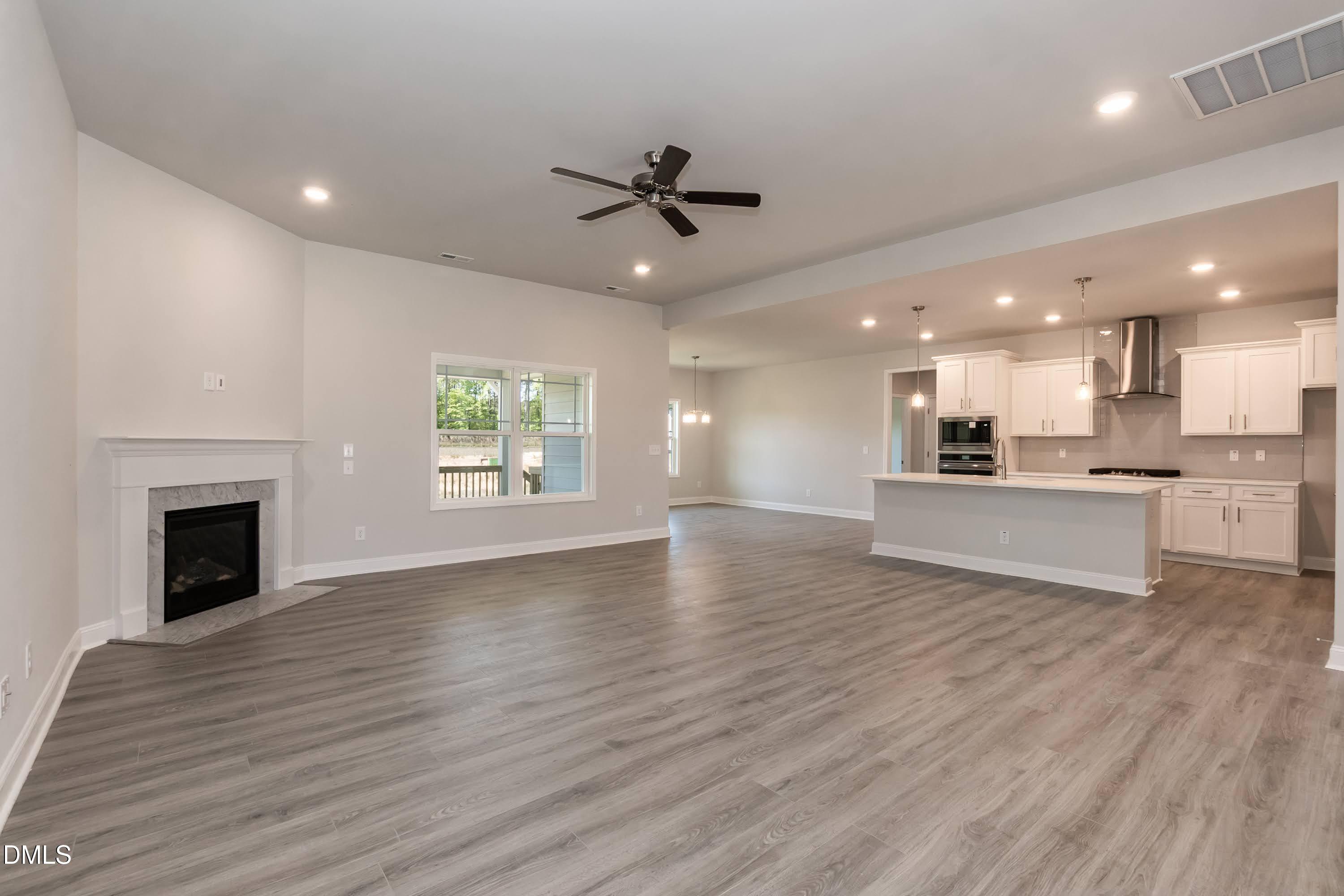 49 Galway Road Lillington, NC 27546 - Photo 9 of 39 a view of an empty room with a kitchen and a fireplace