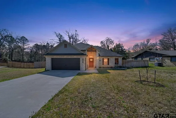 a front view of a house with a garden and yard