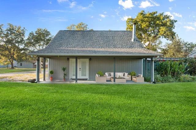 a view of a house with a yard and sitting area