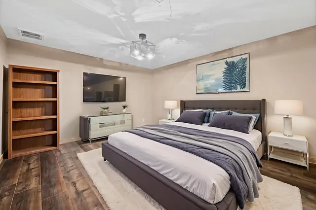 a spacious bedroom with a bed and a flat screen tv