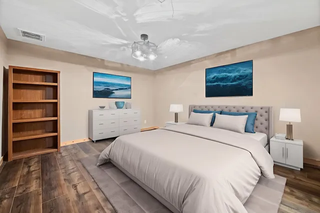 a spacious bedroom with a bed and a ceiling fan