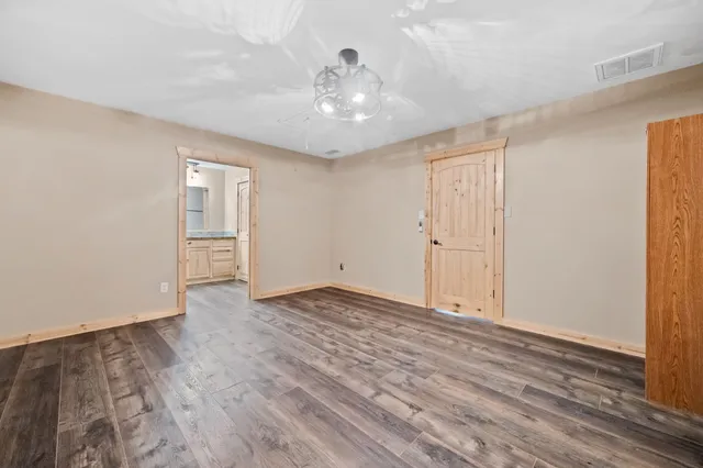 a view of an empty room with wooden floor