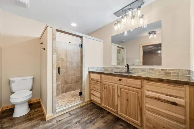 a spacious bathroom with a shower sink vanity mirror and toilet