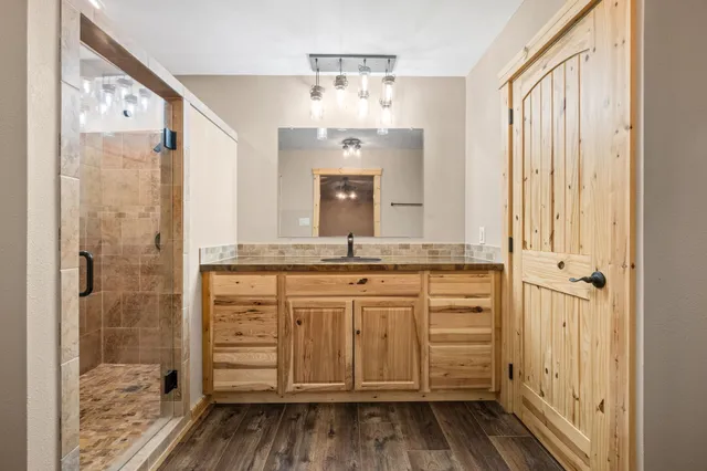 a bathroom with a granite countertop sink a mirror and a shower