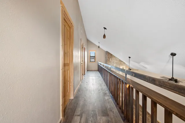 a view of a hallway with wooden floor and staircase