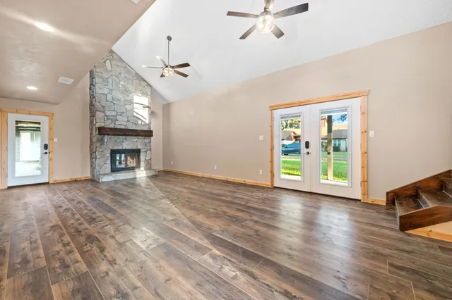 wooden floor fireplace and windows in an empty room