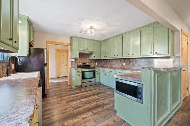 a kitchen with granite countertop a stove and cabinets