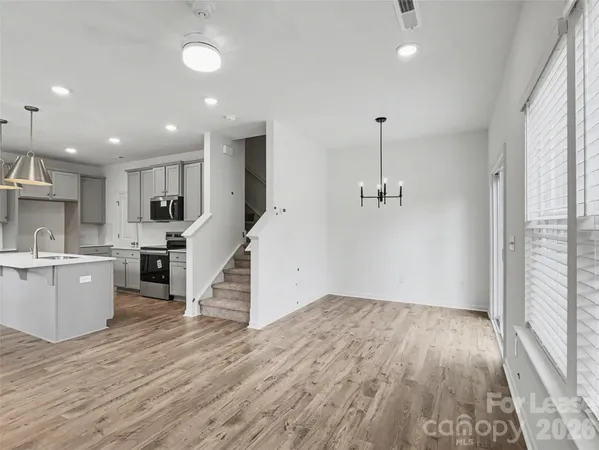 a view of a kitchen with wooden floor and electronic appliances