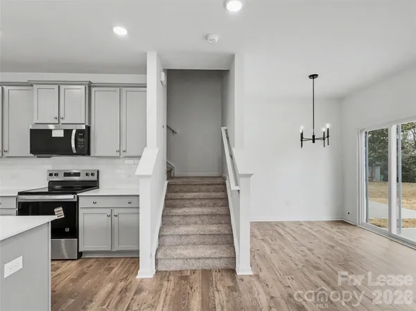 a kitchen with granite countertop a refrigerator and a stove top oven