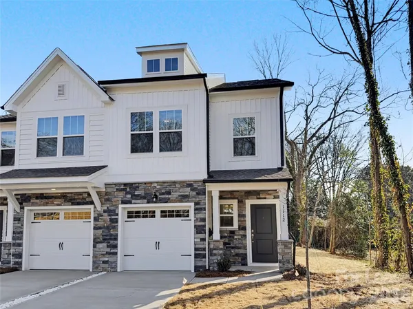 a view of a white house with a large tree