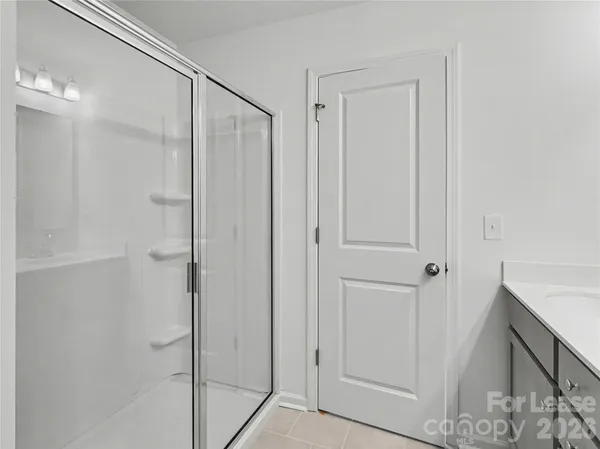 a bathroom with a shower and a glass door