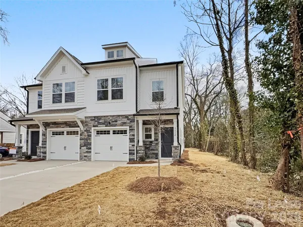a view of a white house with a large tree
