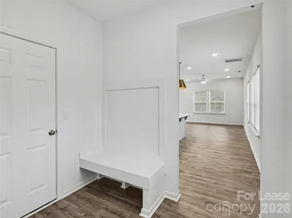 a view of a hallway with wooden floor and staircase