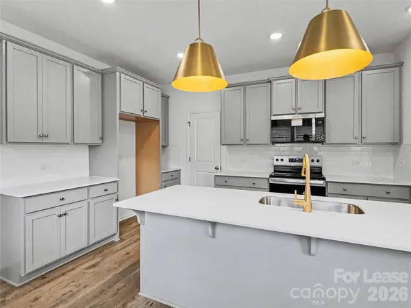 a kitchen with stainless steel appliances a sink a refrigerator and cabinets