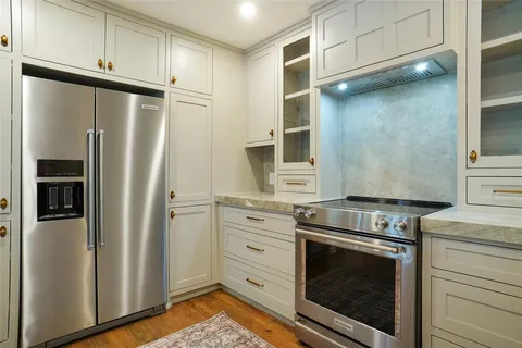 a kitchen with granite countertop white cabinets and white appliances