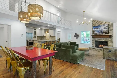 a living room with furniture a dining table and kitchen chandelier