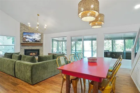 a view of a dining room with furniture a chandelier and wooden floor