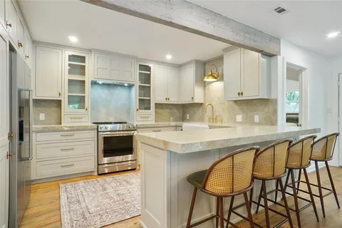 a kitchen with stainless steel appliances granite countertop a stove a sink and a refrigerator