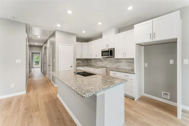 a kitchen with kitchen island a sink stove and refrigerator