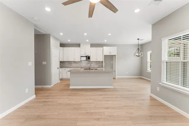 a large kitchen with kitchen island a sink stainless steel appliances and cabinets