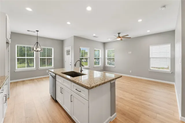 a kitchen with stainless steel appliances granite countertop a sink and a large window