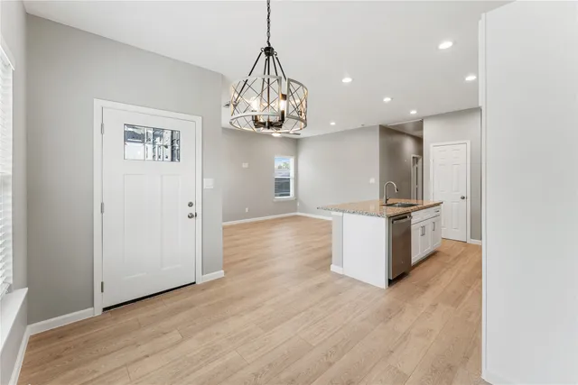 a view of a kitchen with cabinets and wooden floor