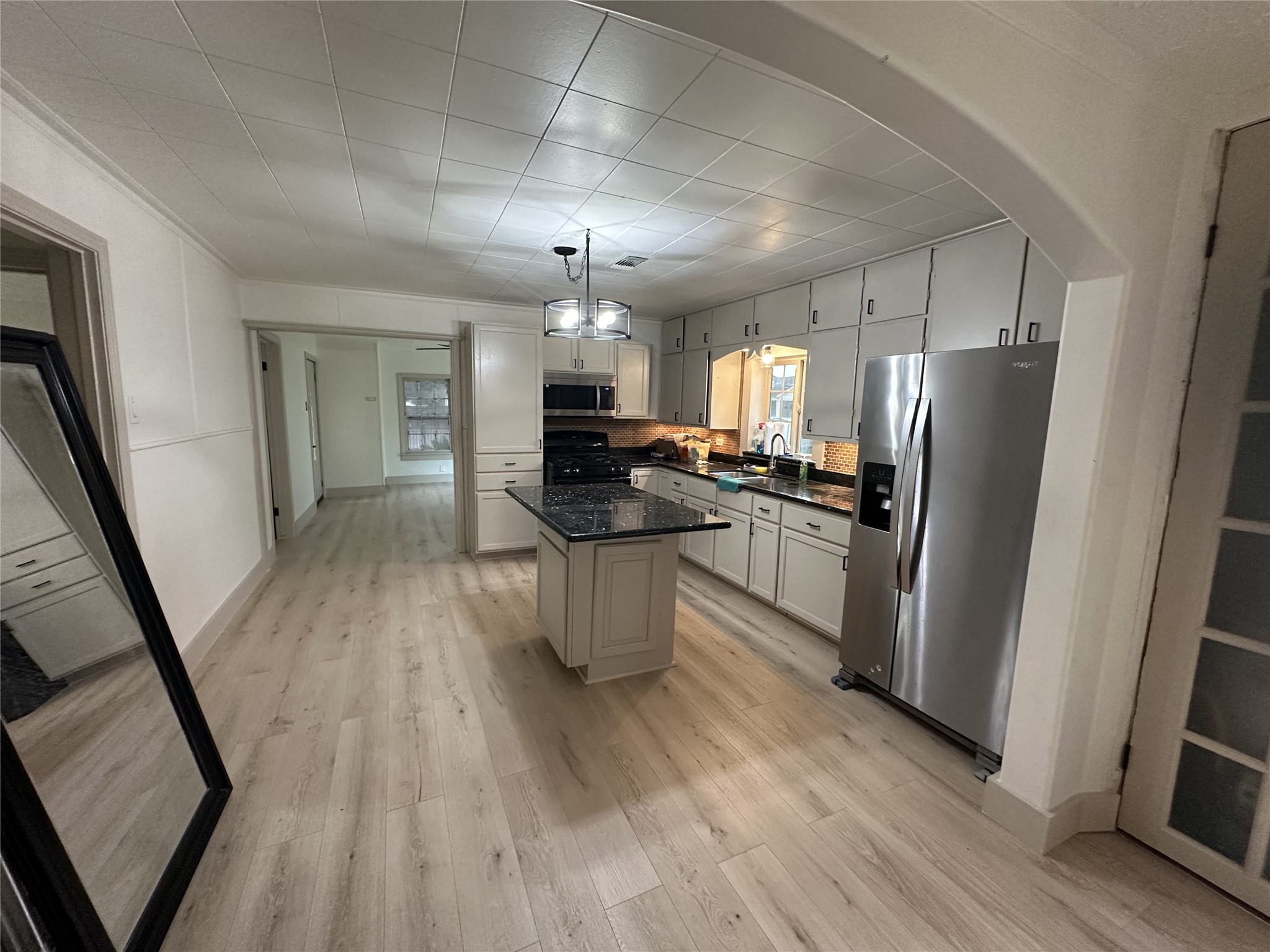 1747 5th Street Rosenberg, TX 77471 - Photo 2 of 10 a kitchen with stainless steel appliances a refrigerator a sink dishwasher a stove and white countertops with wooden floor