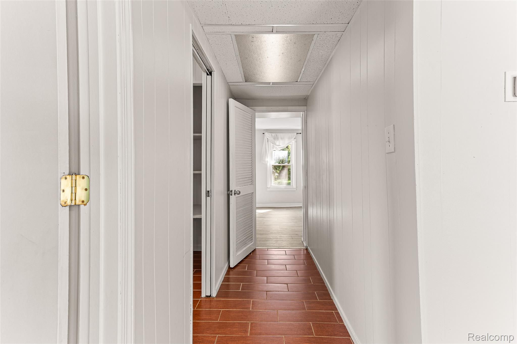 2550 Loon Lake Road Wixom, MI 48393 - Photo 20 of 36 Hallway with tile flooring, vertical paneling, and a built-in closet with shelving