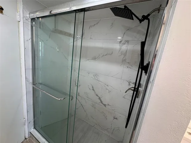 a bathroom with a glass door shower and vanity