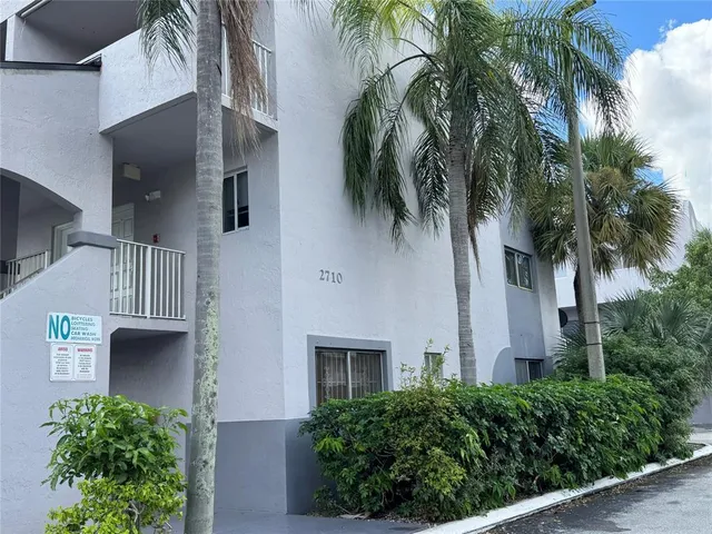 a view of a house with a plants next to a road