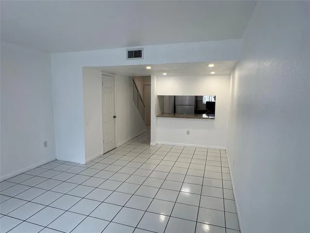 a view of a hallway to room with wooden floor