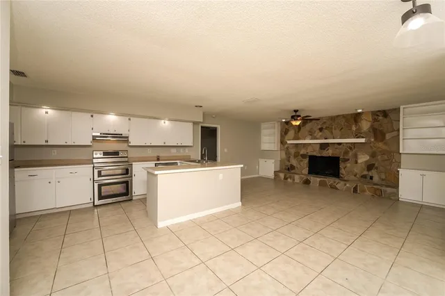 a kitchen with a sink stainless steel appliances and white cabinets