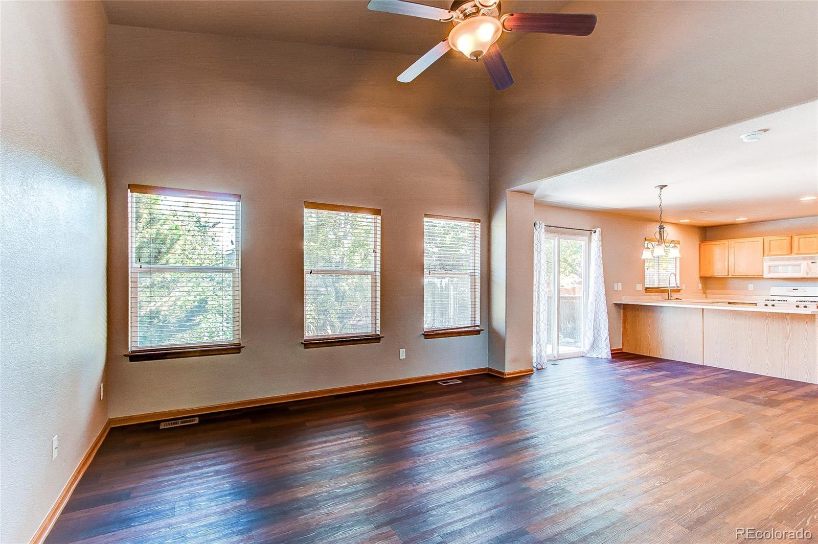 9776 Gatesbury Circle Highlands Ranch, CO 80126 - Photo 4 of 24 a view of an empty room with wooden floor and a window