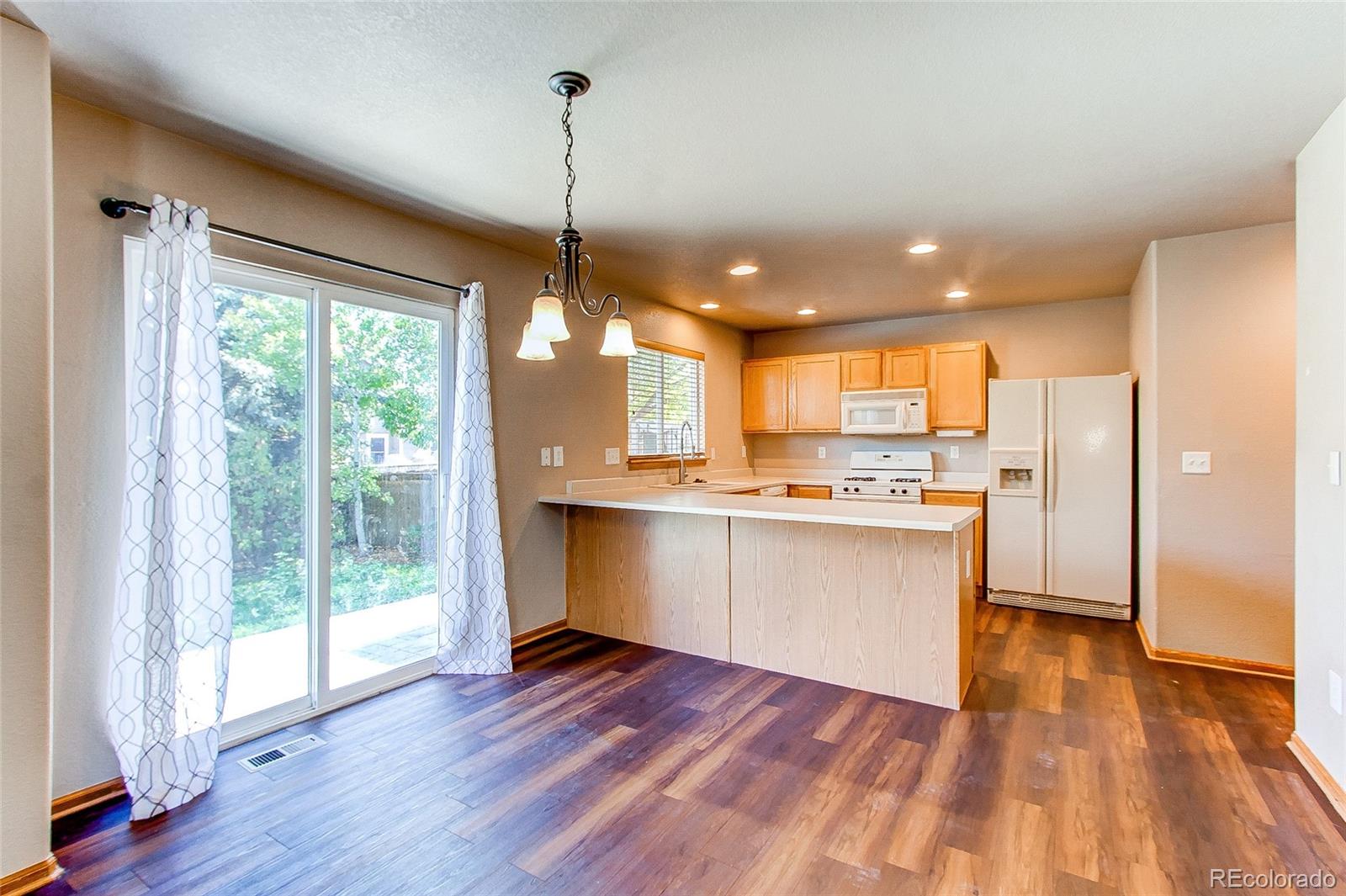 9776 Gatesbury Circle Highlands Ranch, CO 80126 - Photo 6 of 24 a view of kitchen with granite countertop stainless steel appliances cabinets and a wooden floor